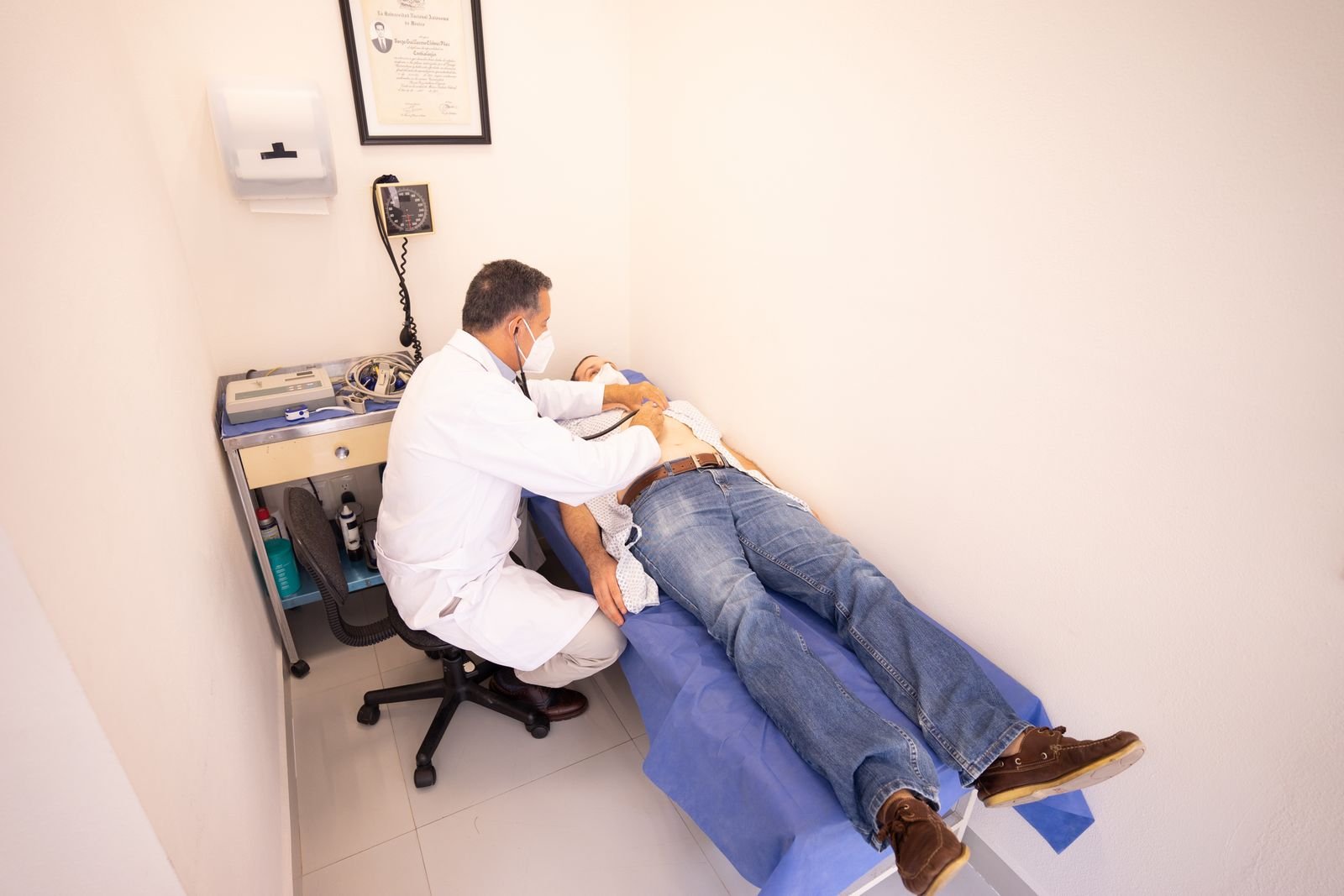 Clinician examining a patient in an exam room, because clear documentation prevents coding denials
