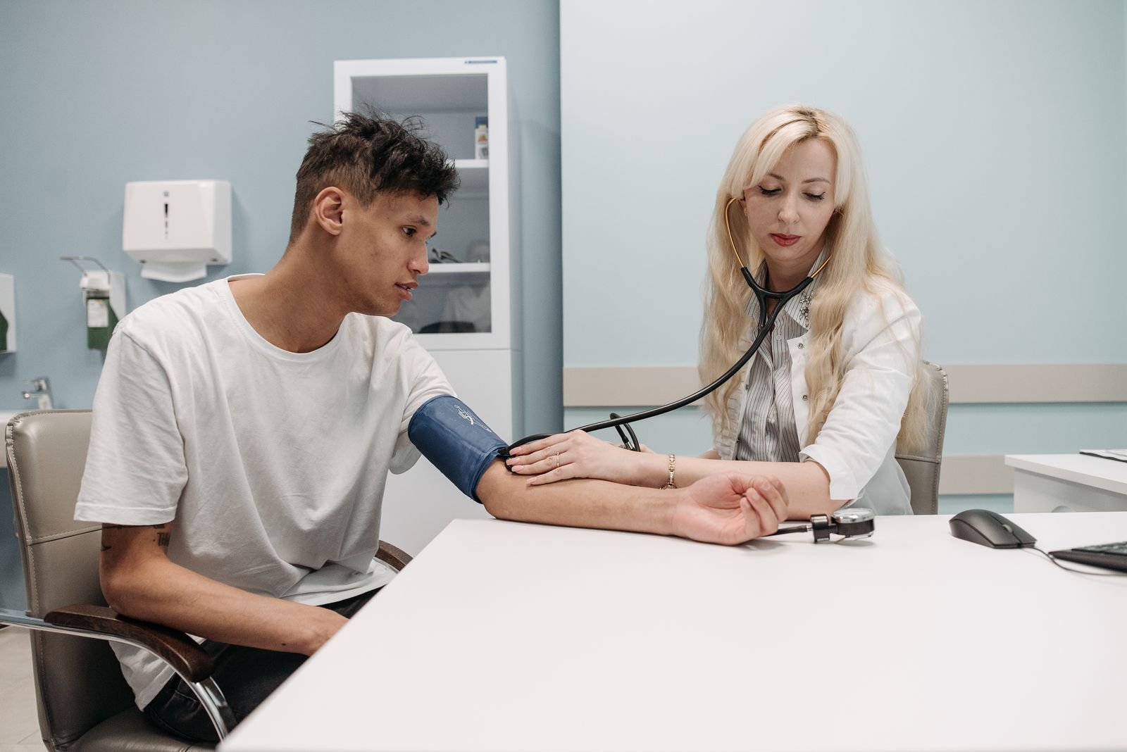 Provider checking blood pressure during an urgent care visit, where charge capture begins
